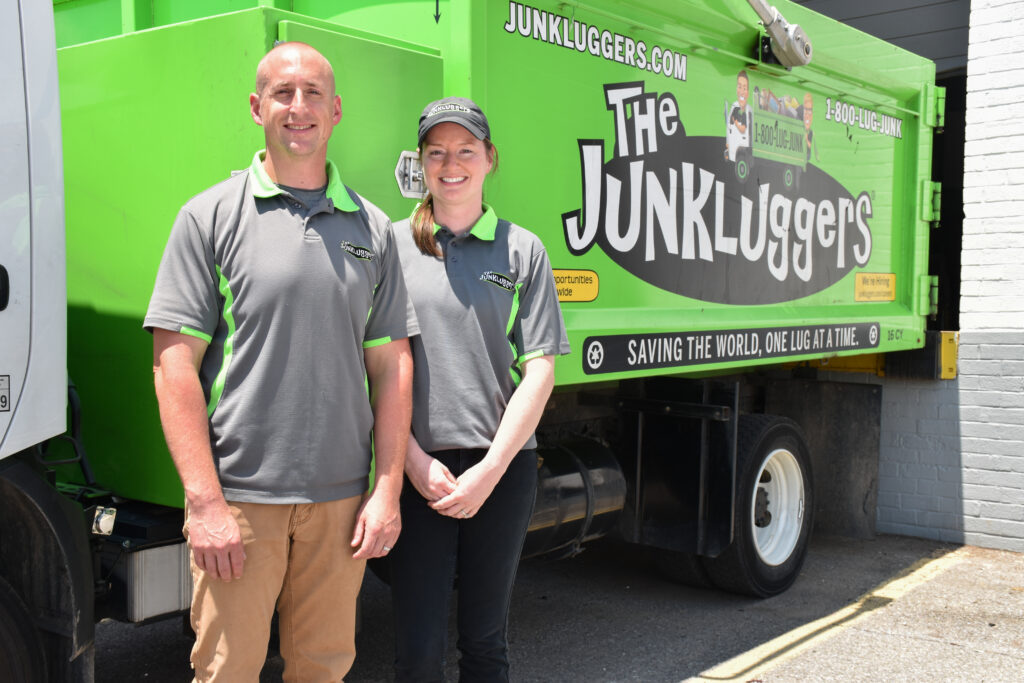 Two employees standing outside of the Junkluggers truck